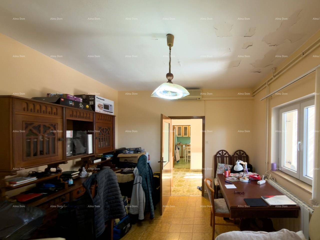 Wohnzimmer mit Esstisch, Schrank und Blick in die Küche.
