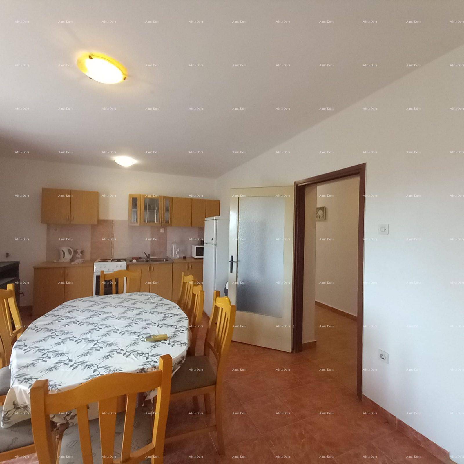 Offene Küche mit Essbereich, hellen Holzschränken und einem Esstisch für mehrere Personen.
