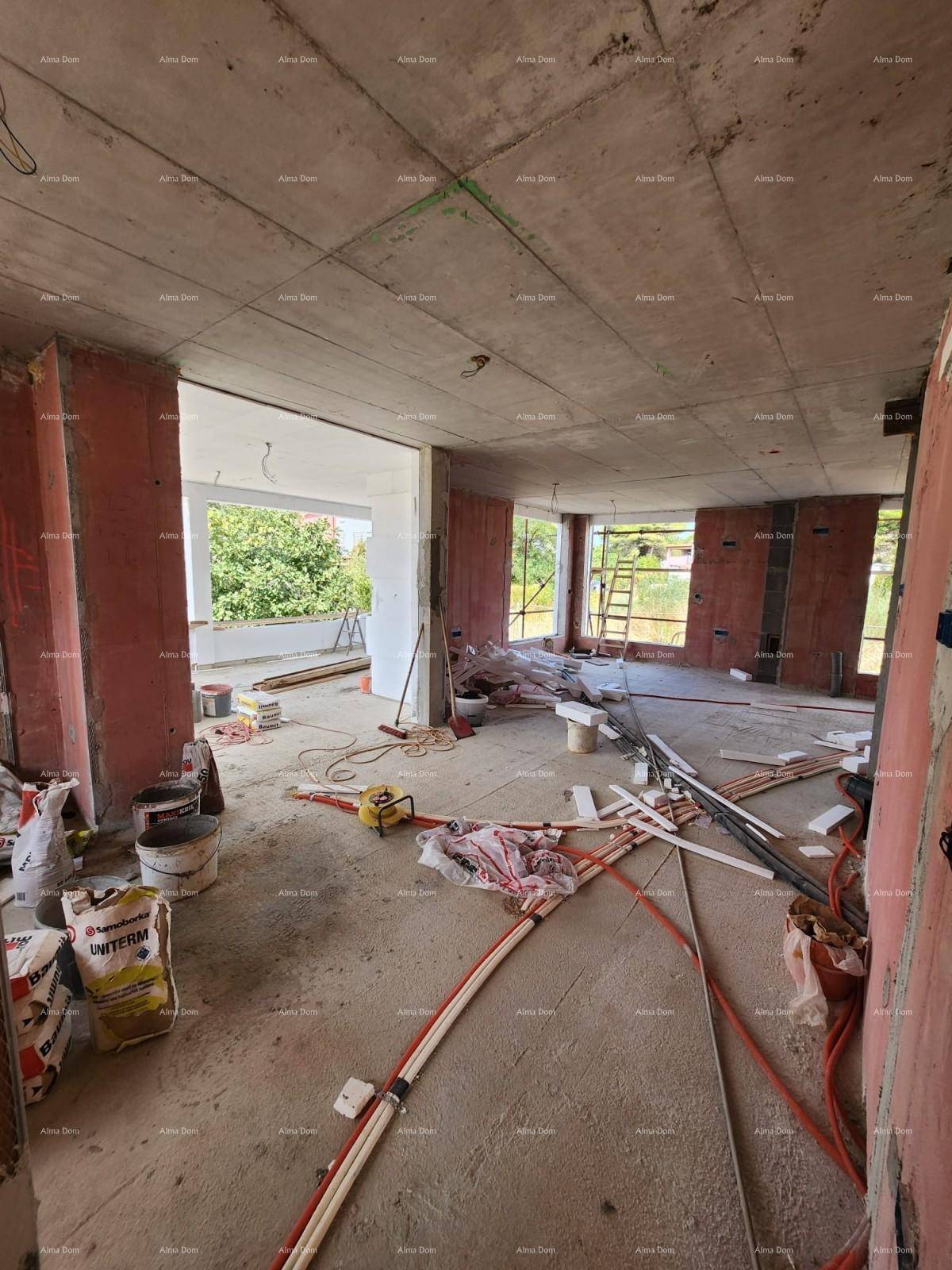Innenraum im Rohbau mit unverputzten Ziegelwänden, Betonboden und großem Zugang zu einem Außenbereich.