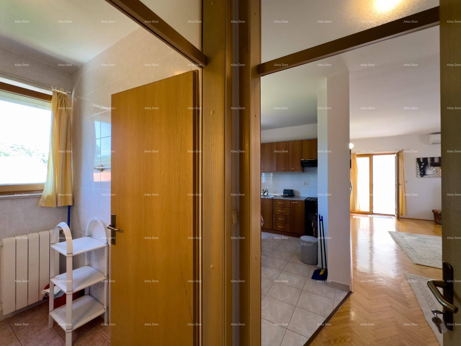 Flur mit Blick auf das Badezimmer und den offenen Wohn-Essbereich.