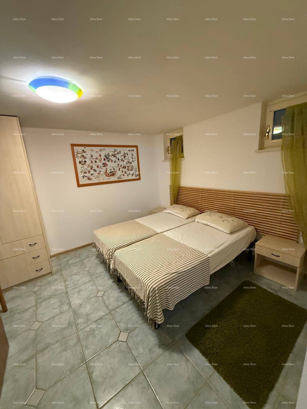 Schlafzimmer mit zwei Einzelbetten, Fliesenboden und Holzvertäfelung am Kopfende der Betten.