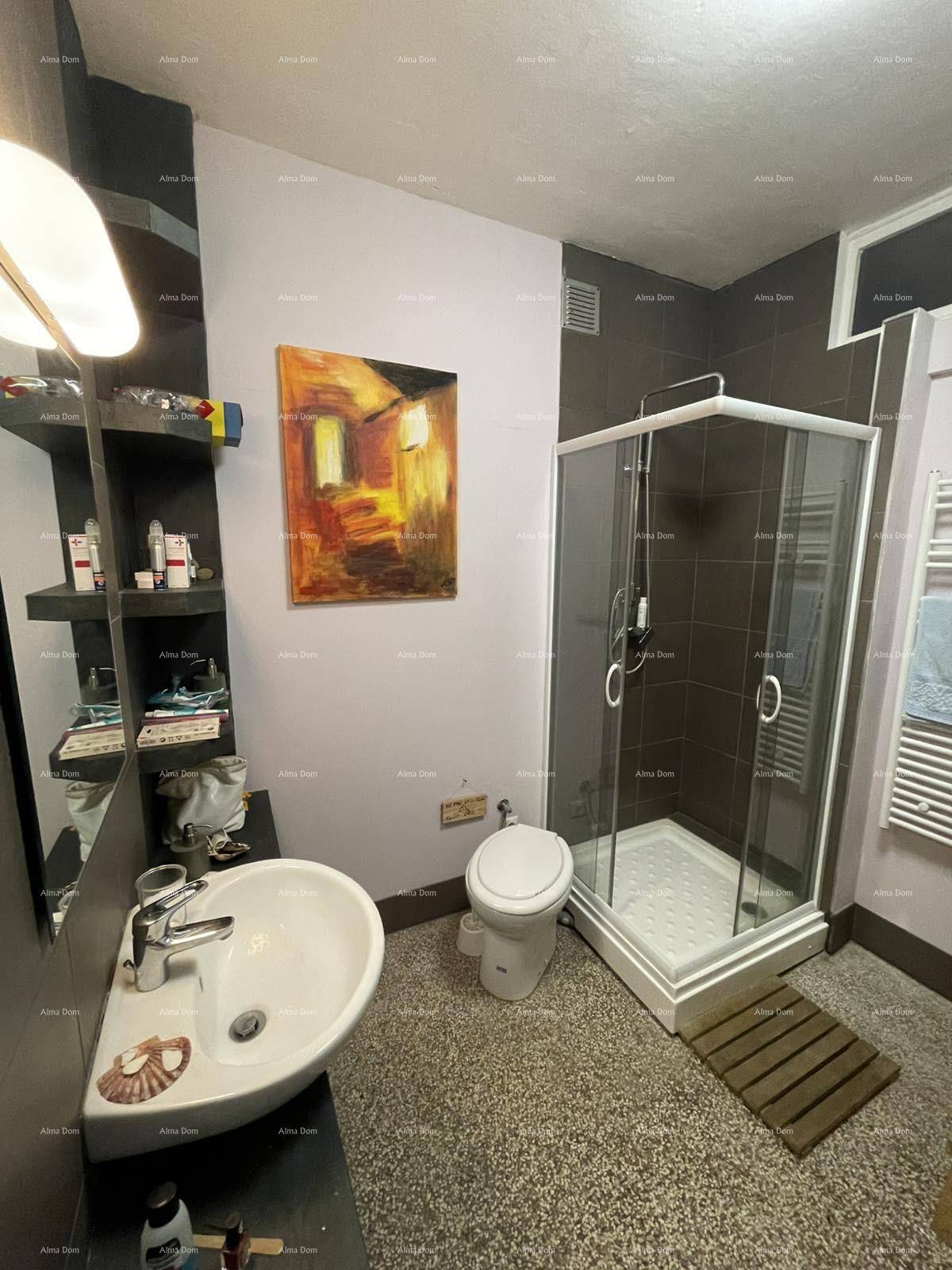 Badezimmer mit Duschkabine, Waschbecken und Toilette, mit dunklen Fliesen und modernem Design.