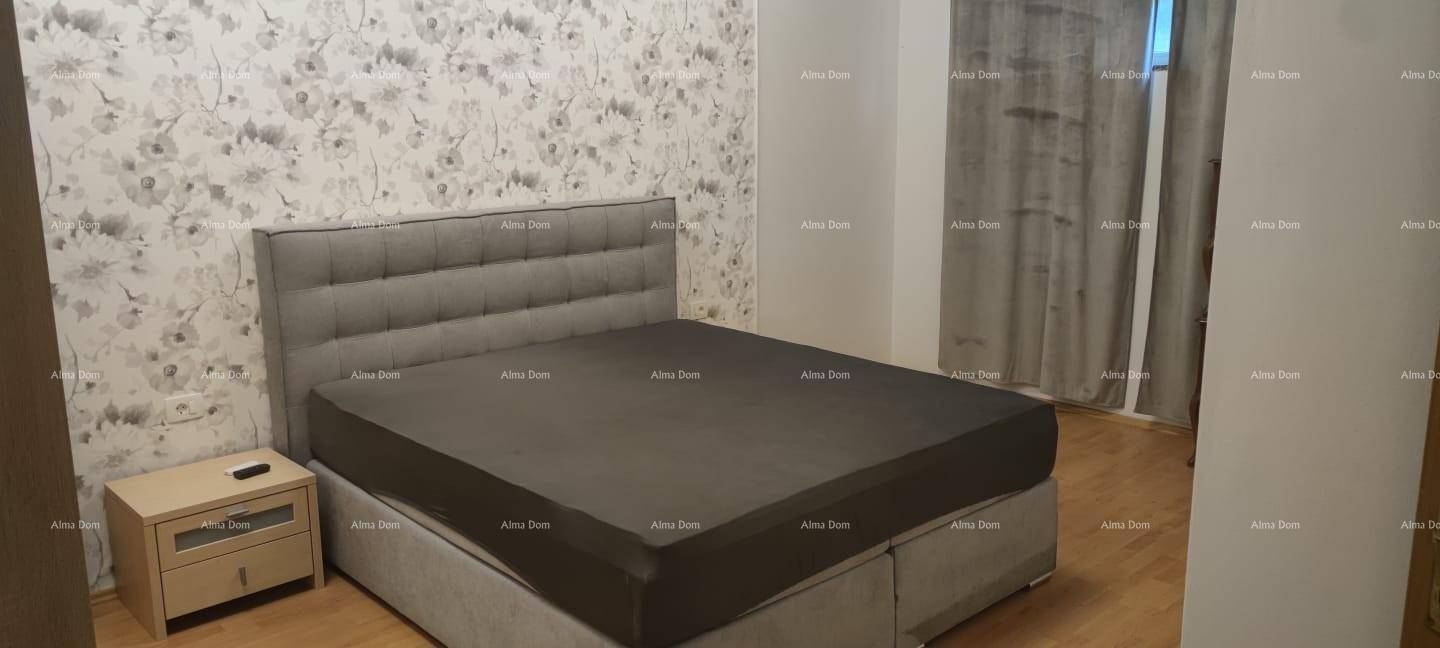 Schlafzimmer mit großem Bett, Nachttisch und dekorativer floraler Tapete an der Wand.