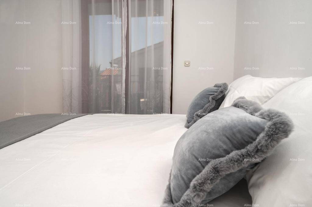 Nahaufnahme des Bettes im Schlafzimmer mit weichen grauen Kissen und heller Bettwäsche.