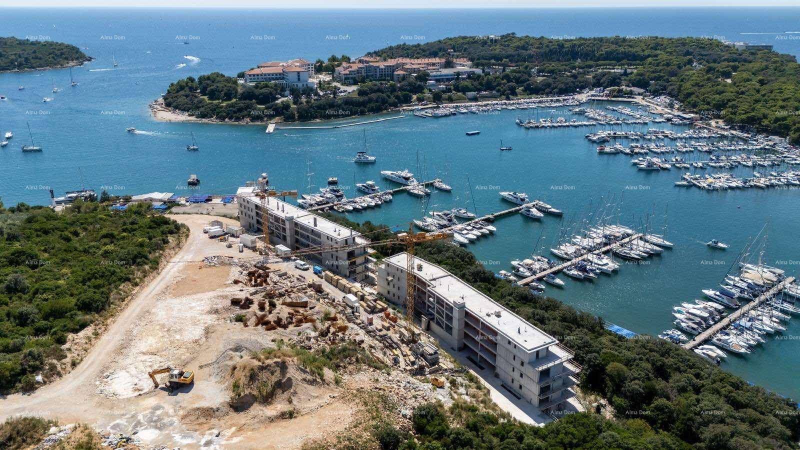 Luftaufnahme einer Baustelle und eines Yachthafens entlang der Küste mit vielen Booten.