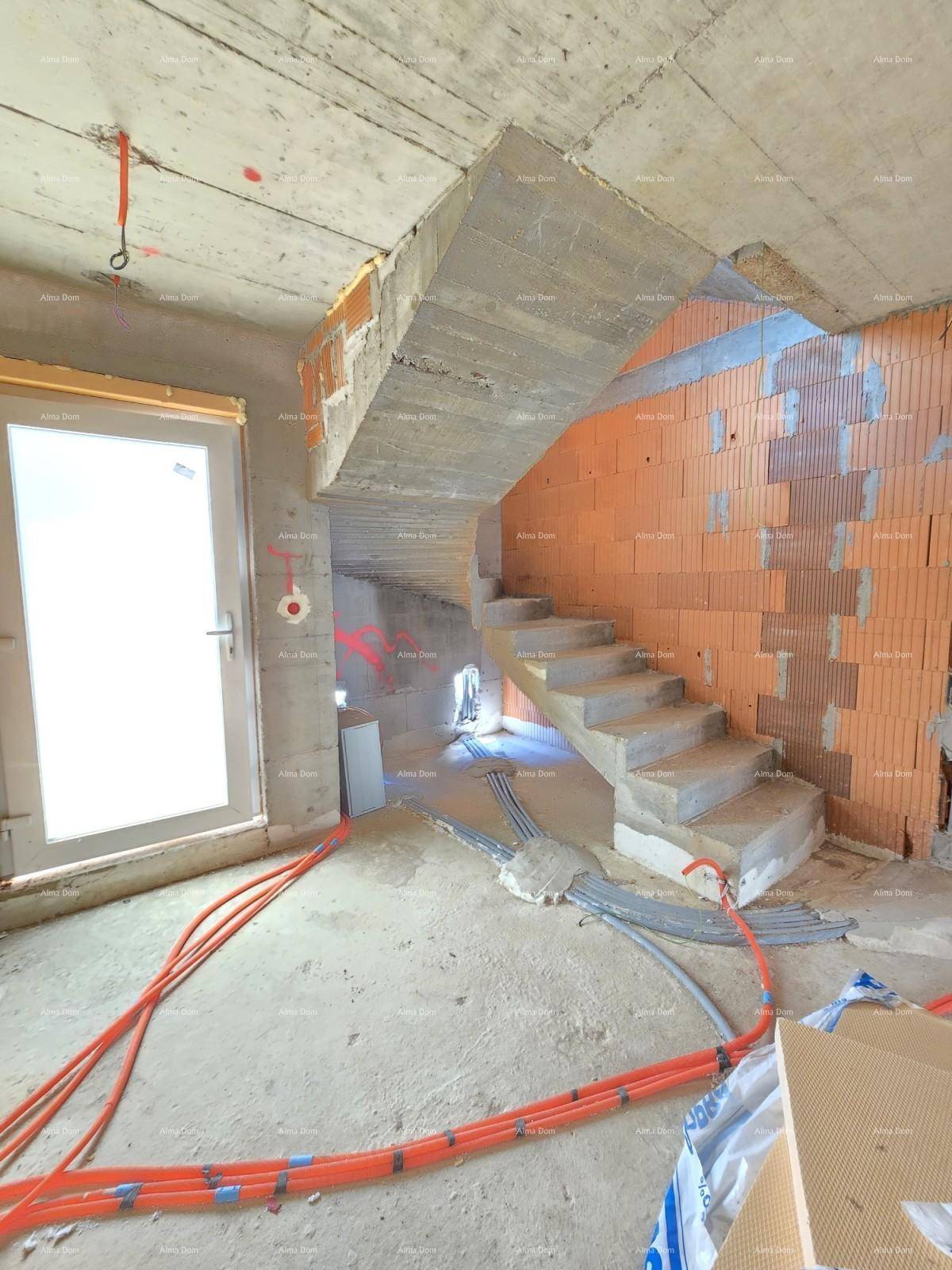 Innenbereich im Rohbau mit Betontreppe, unverputzten Ziegelwänden und sichtbaren Installationen.