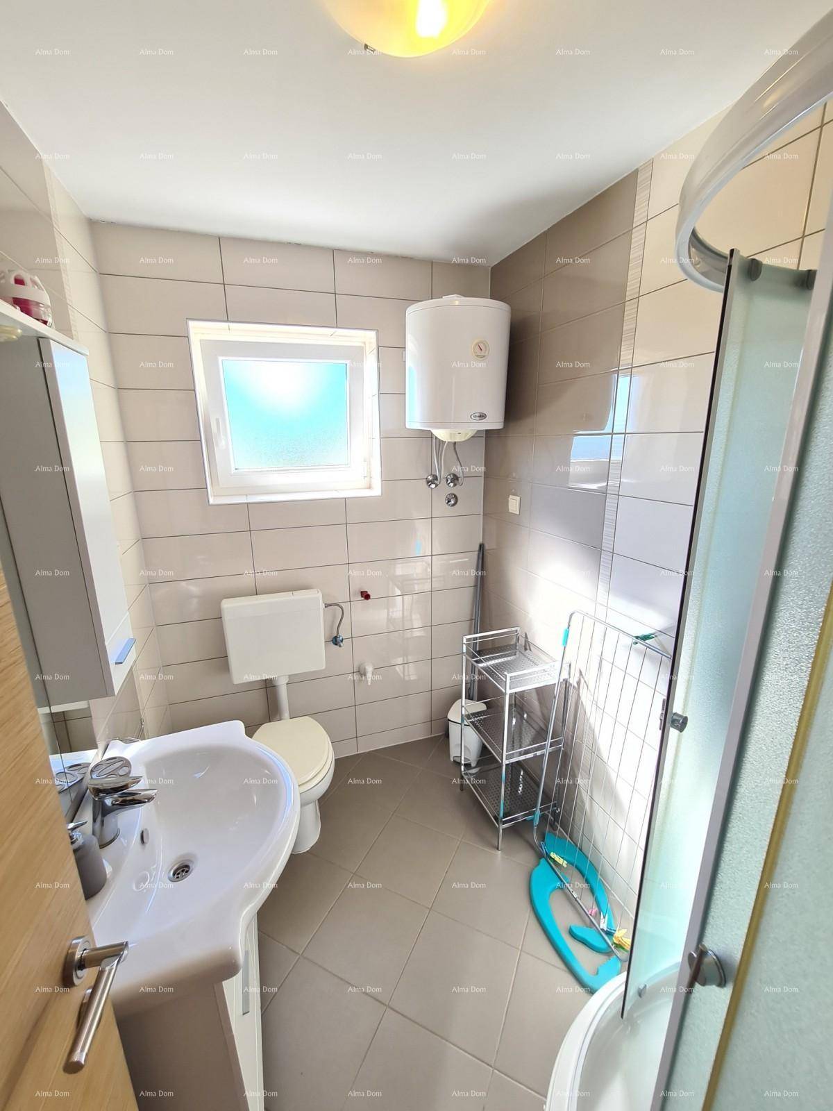 Funktionales Badezimmer mit Duschkabine, WC, Waschbecken und Fenster, praktisch eingerichtet.