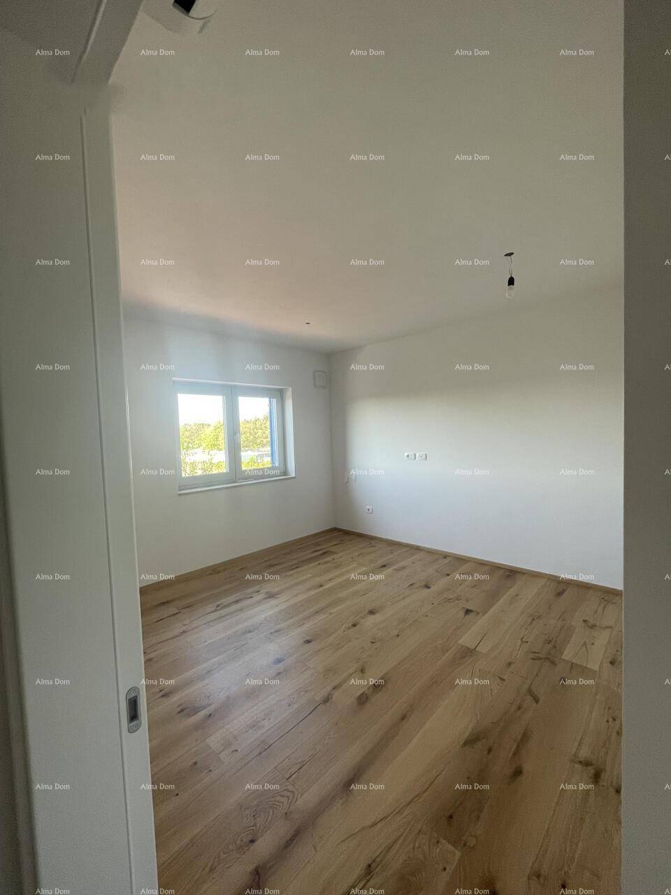 Geräumiges Schlafzimmer mit Holzboden und großem Fenster, das viel Tageslicht bietet.