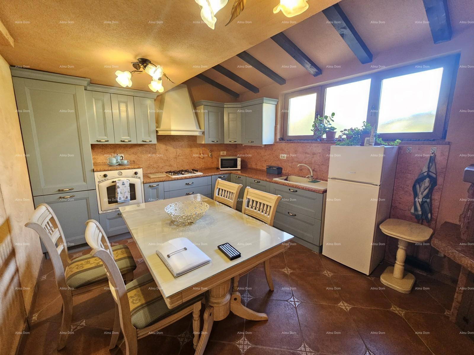 Rustikale Küche mit hellblauen Schränken, einem Esstisch und sichtbaren Holzbalken an der Decke.
