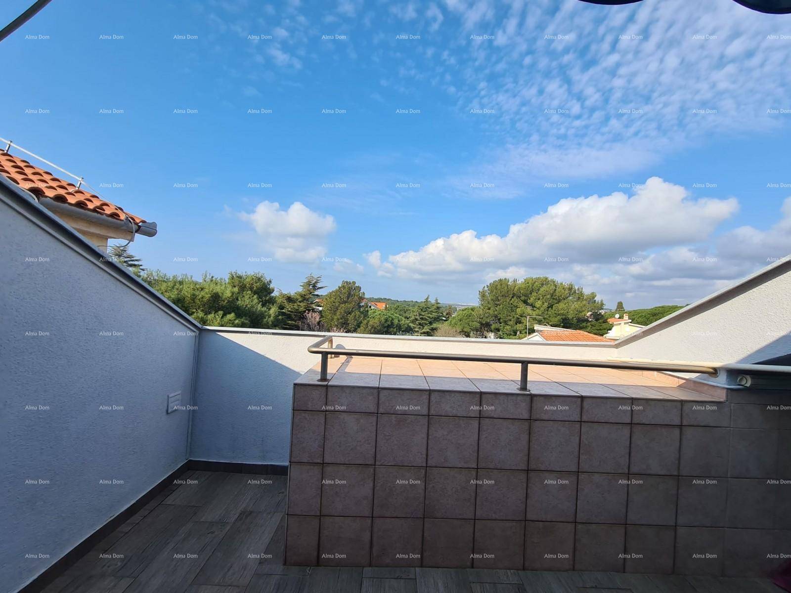Geräumige Außenterrasse mit Fliesenboden und einer niedrigen, gefliesten Brüstung unter blauem Himmel.