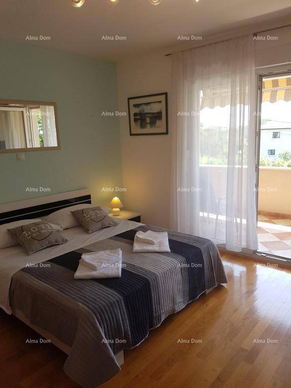 Schlafzimmer mit Doppelbett, Holzfußboden und direktem Zugang zum Balkon für frische Luft.