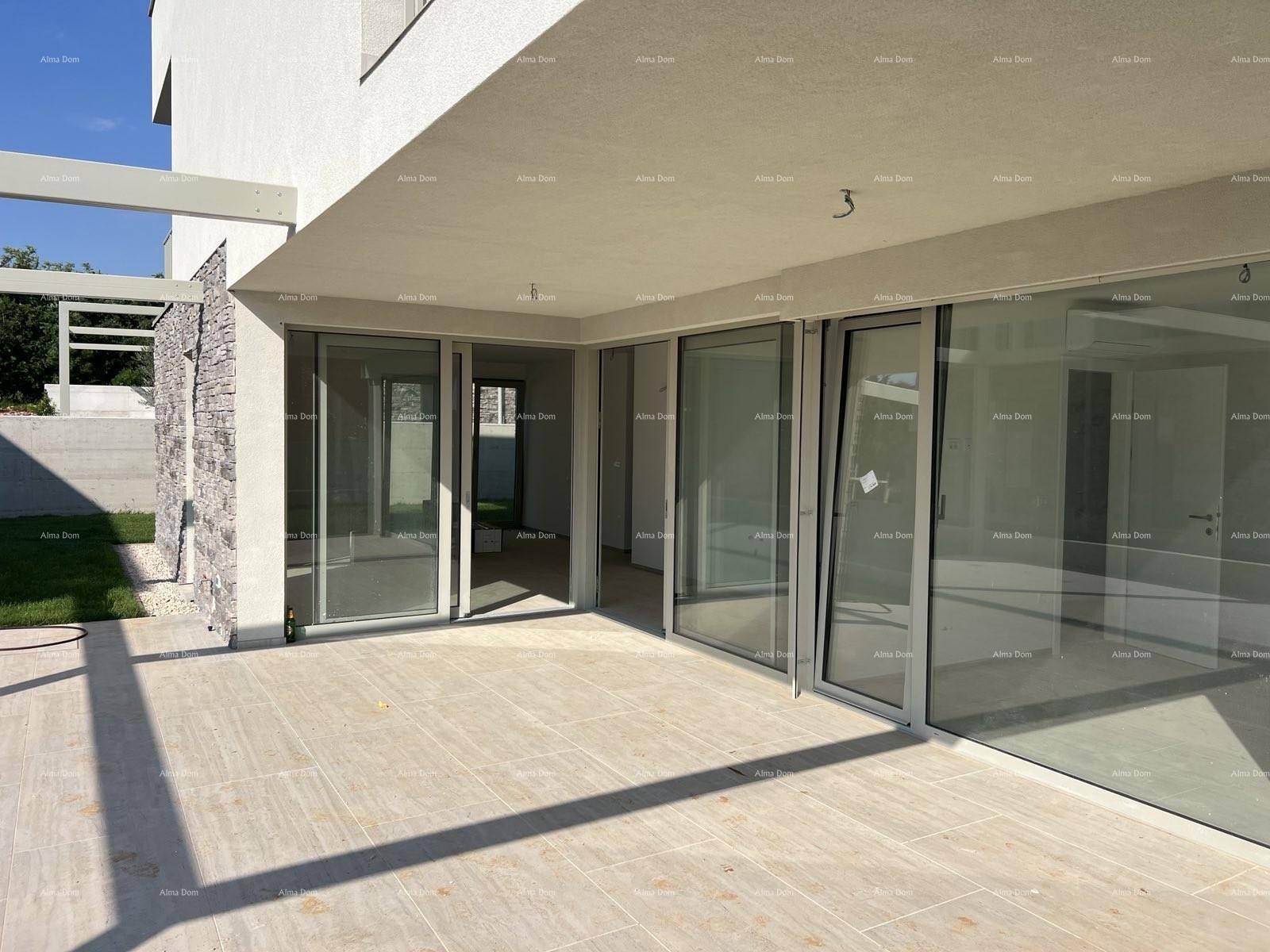 Geräumige, geflieste Terrasse mit großen Glasfronten und Zugang zum Innenbereich.