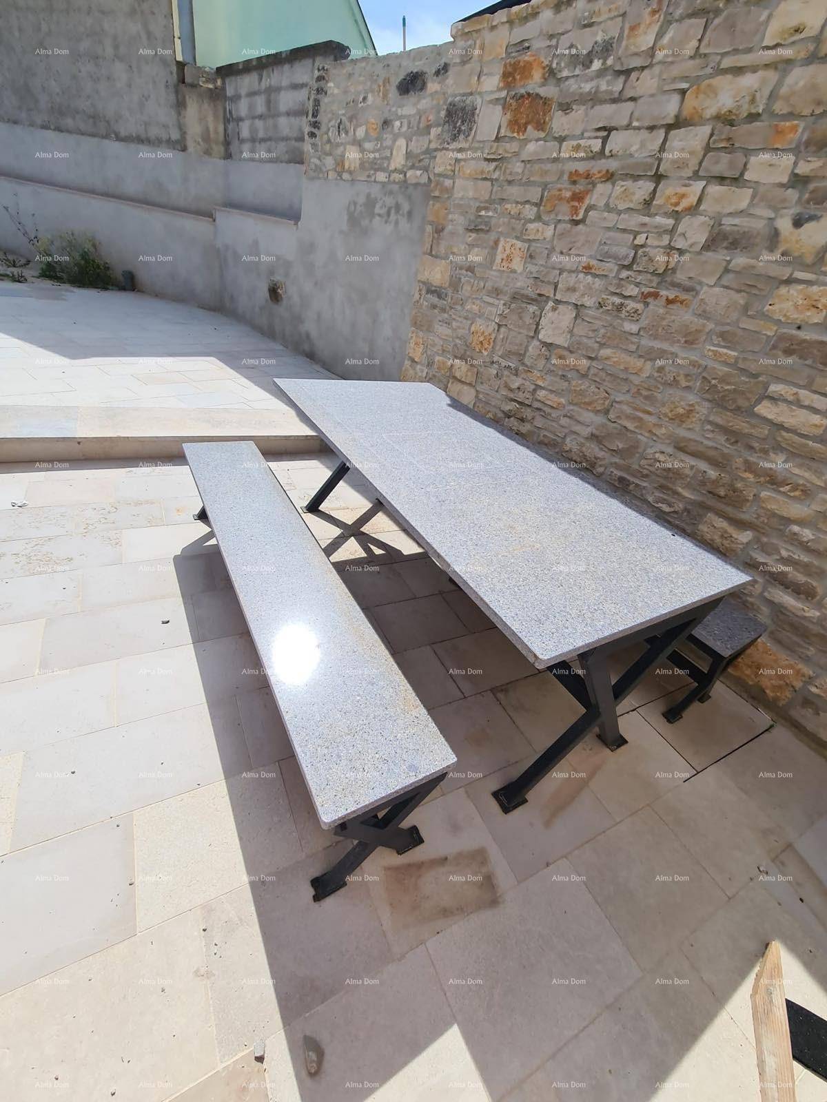 Außenbereich mit Steintisch und Bänken, ideal für Mahlzeiten im Freien.