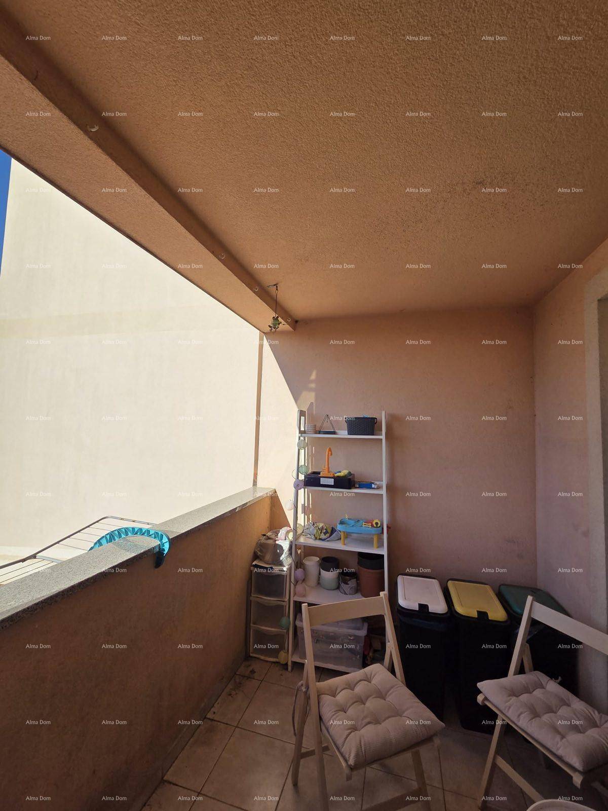 Überdachter Balkon mit Fliesenboden, Stauraum und Blick ins Freie.