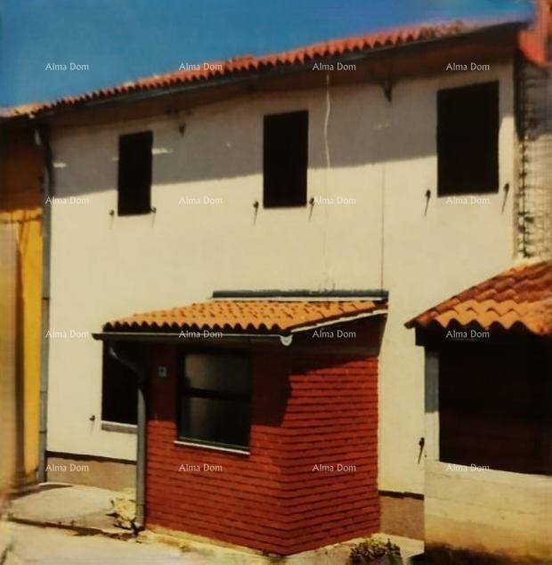 Fassade eines Hauses mit weißem Putz und einem roten Anbau mit Ziegeldach.