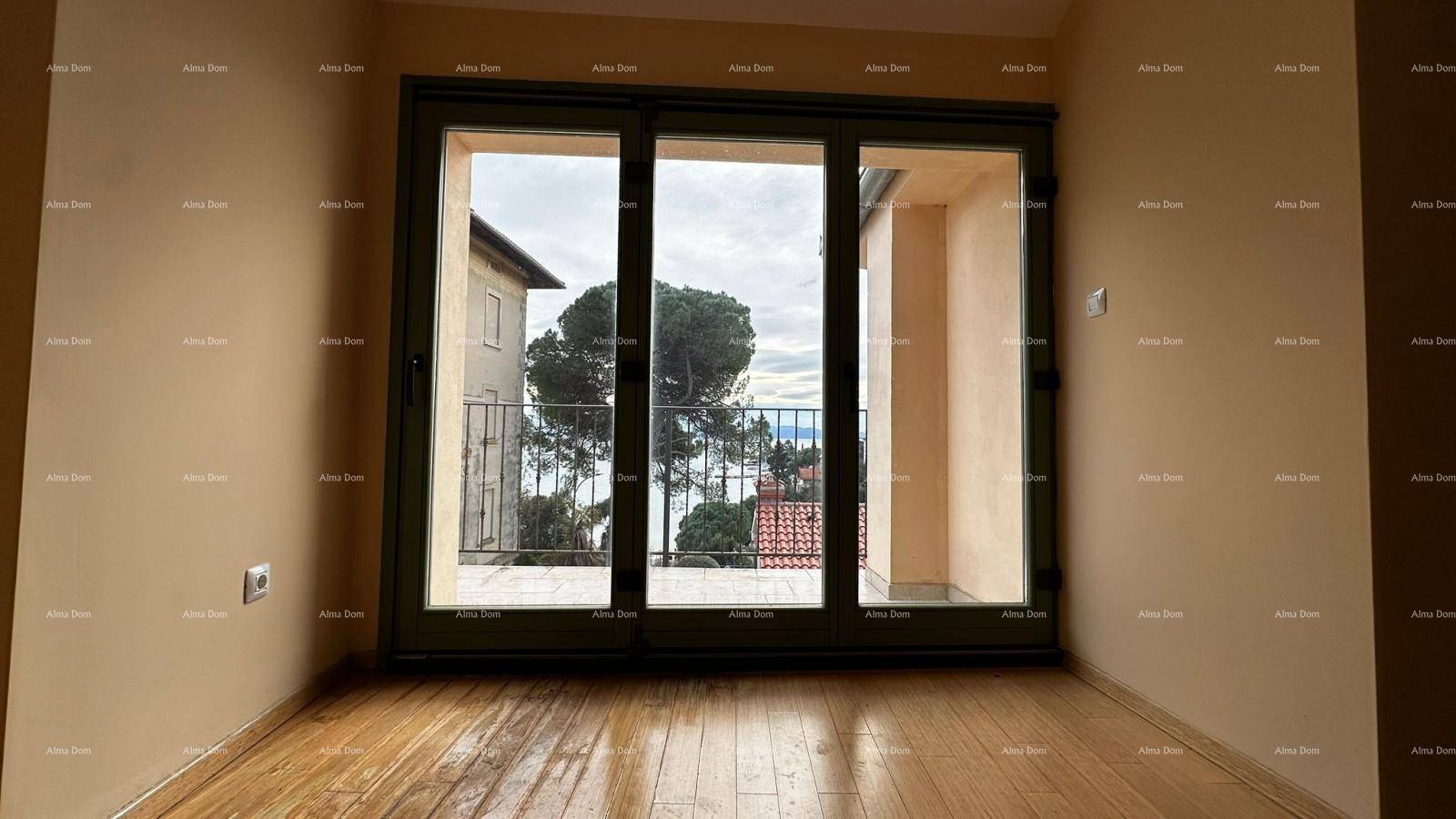 Leerer Raum mit Holzboden und großer Schiebetür, die einen weiten Blick auf das Meer bietet.