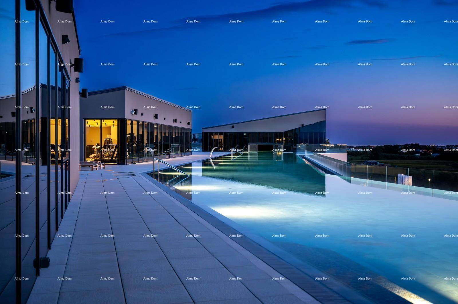 Beleuchteter Dachpool mit Infinity-Rand und moderner Architektur bei Sonnenuntergang.