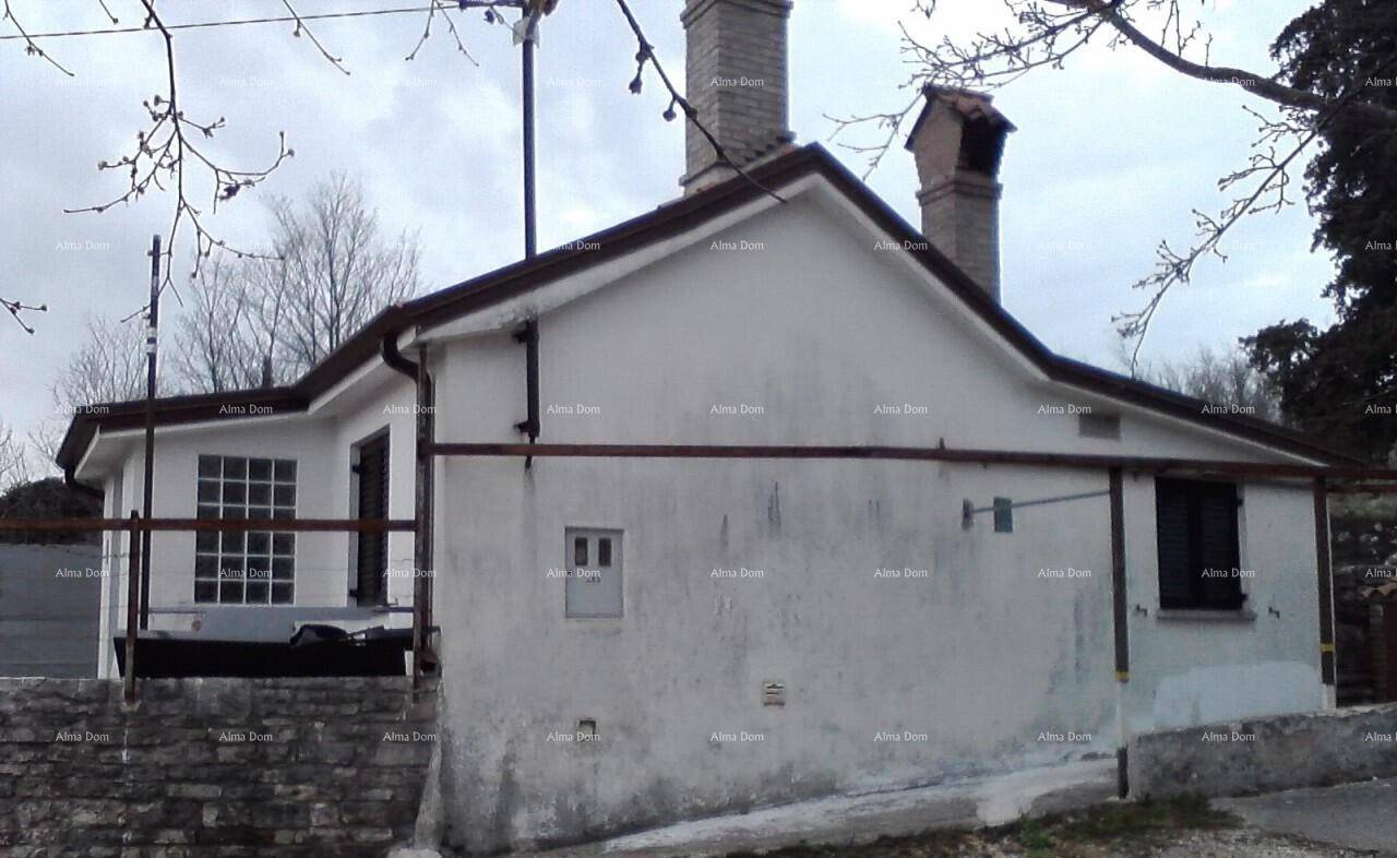 Rückseite eines weißen Hauses mit Ziegeldach, zwei Schornsteinen und einfacher Fassade.