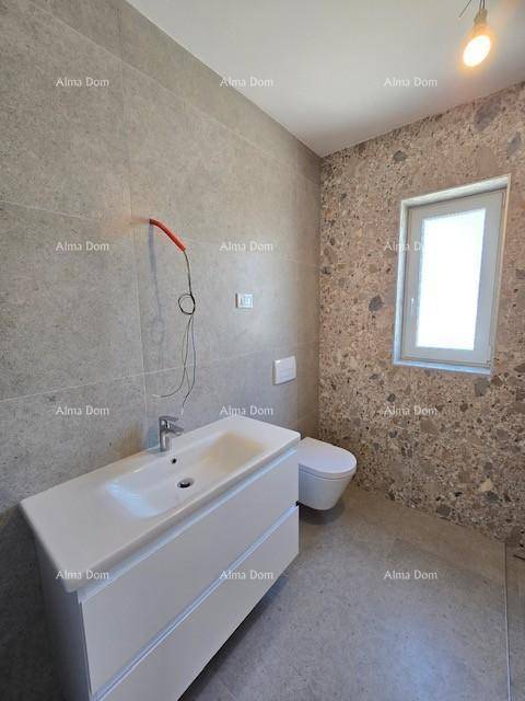 Elegantes Badezimmer mit großem Waschtisch, Wand-WC und dekorativen Fliesen an den Wänden.