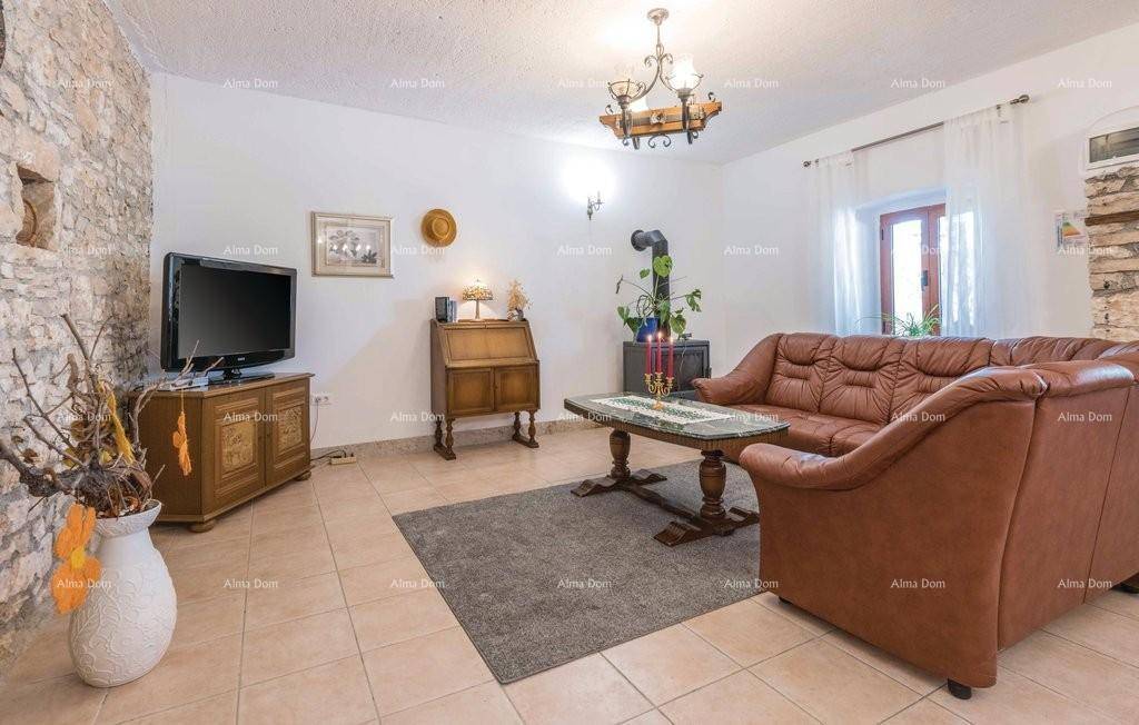 Helles Wohnzimmer mit bequemen Ledersofas, Steinwand und traditionellem Holzofen.