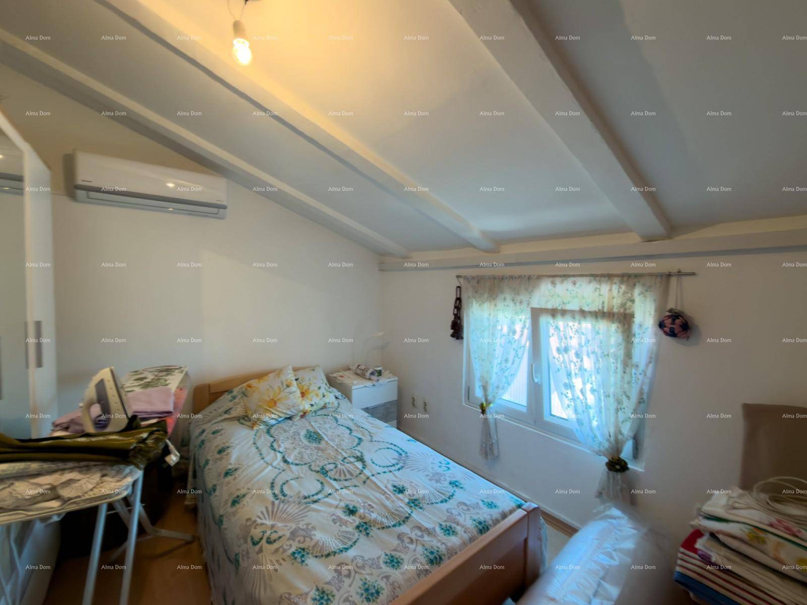 Gemütliches Schlafzimmer mit sichtbaren Deckenbalken, Einzelbett und einem Fenster für Tageslicht.