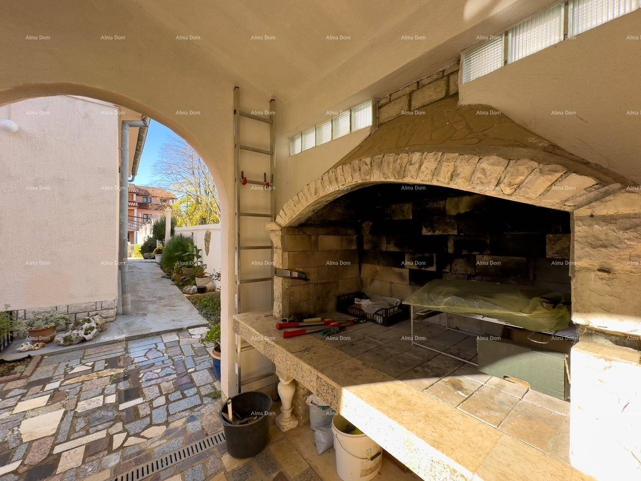 Gemauerter Grillbereich im Freien mit Arbeitsfläche und Zugang zu einem gepflasterten Weg.