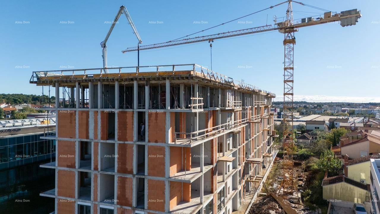 Baustelle eines neuen Gebäudes mit sichtbarer Betonstruktur und Baukränen unter blauem Himmel.