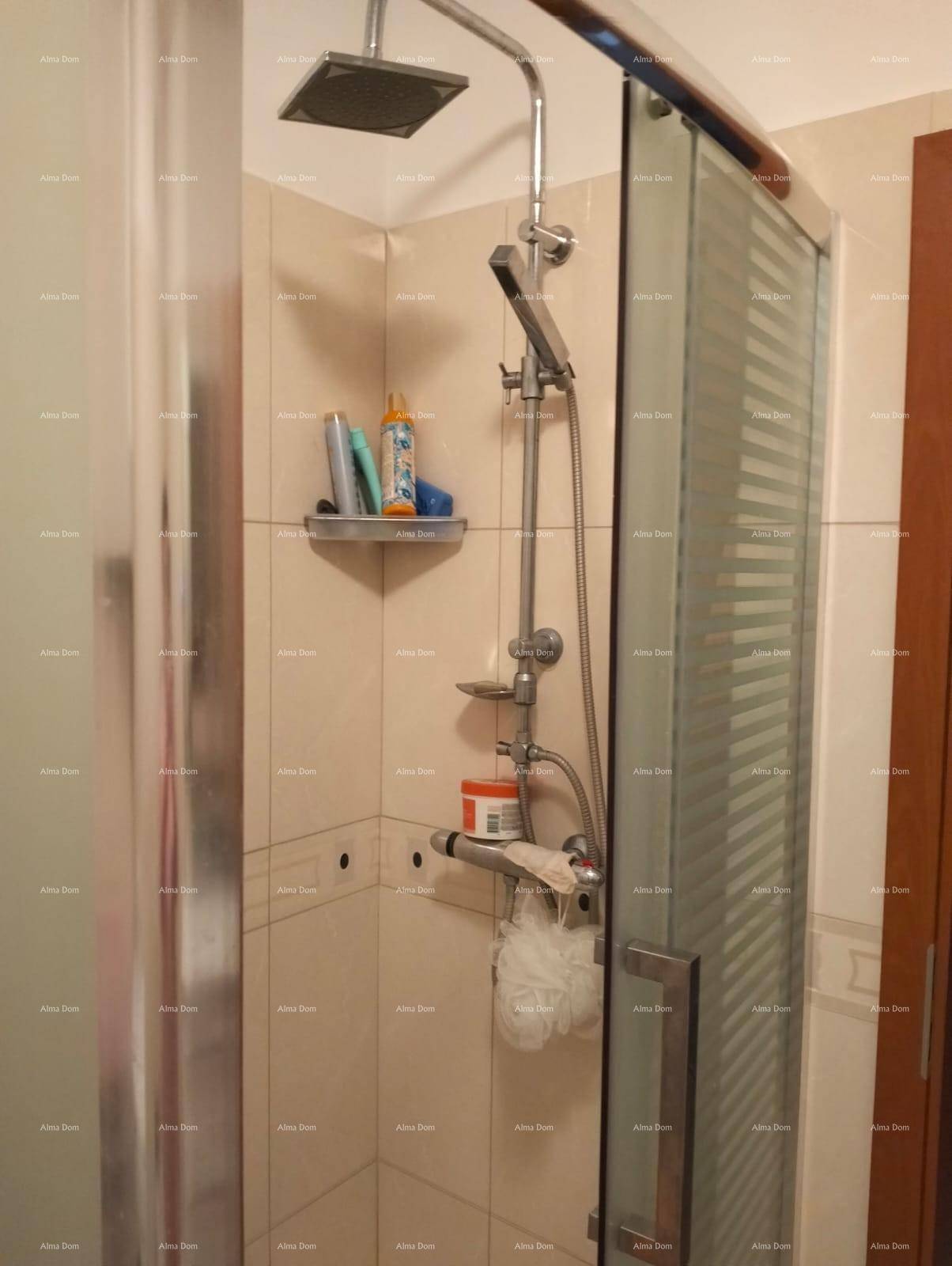 Duschkabine mit Regendusche und Handbrause in einem gefliesten Badezimmerbereich.