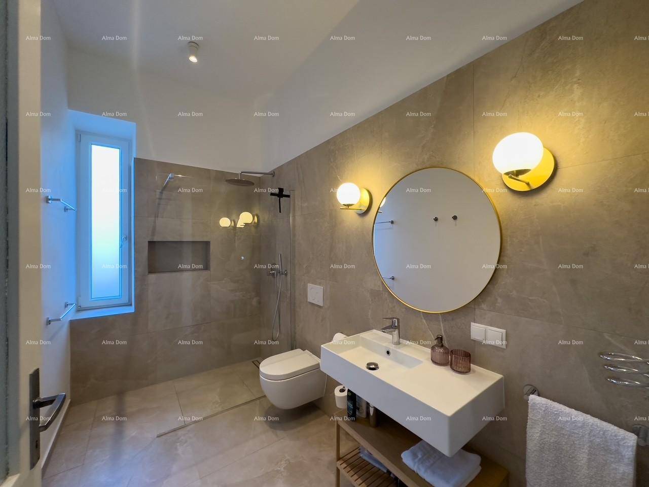 Modernes Badezimmer mit großen grauen Fliesen, begehbarer Dusche und Fenster für Tageslicht.