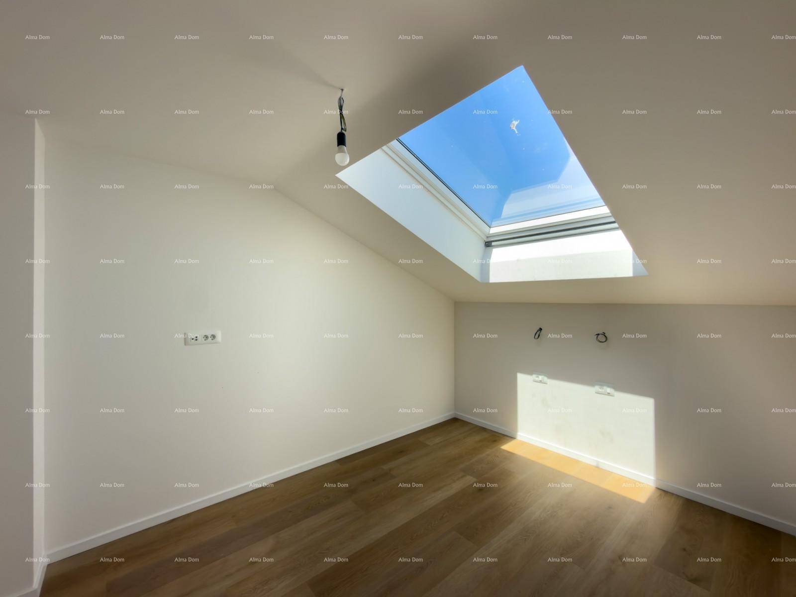 Heller Raum mit Holzboden, großem Oberlicht und schräger Decke für viel Tageslicht.