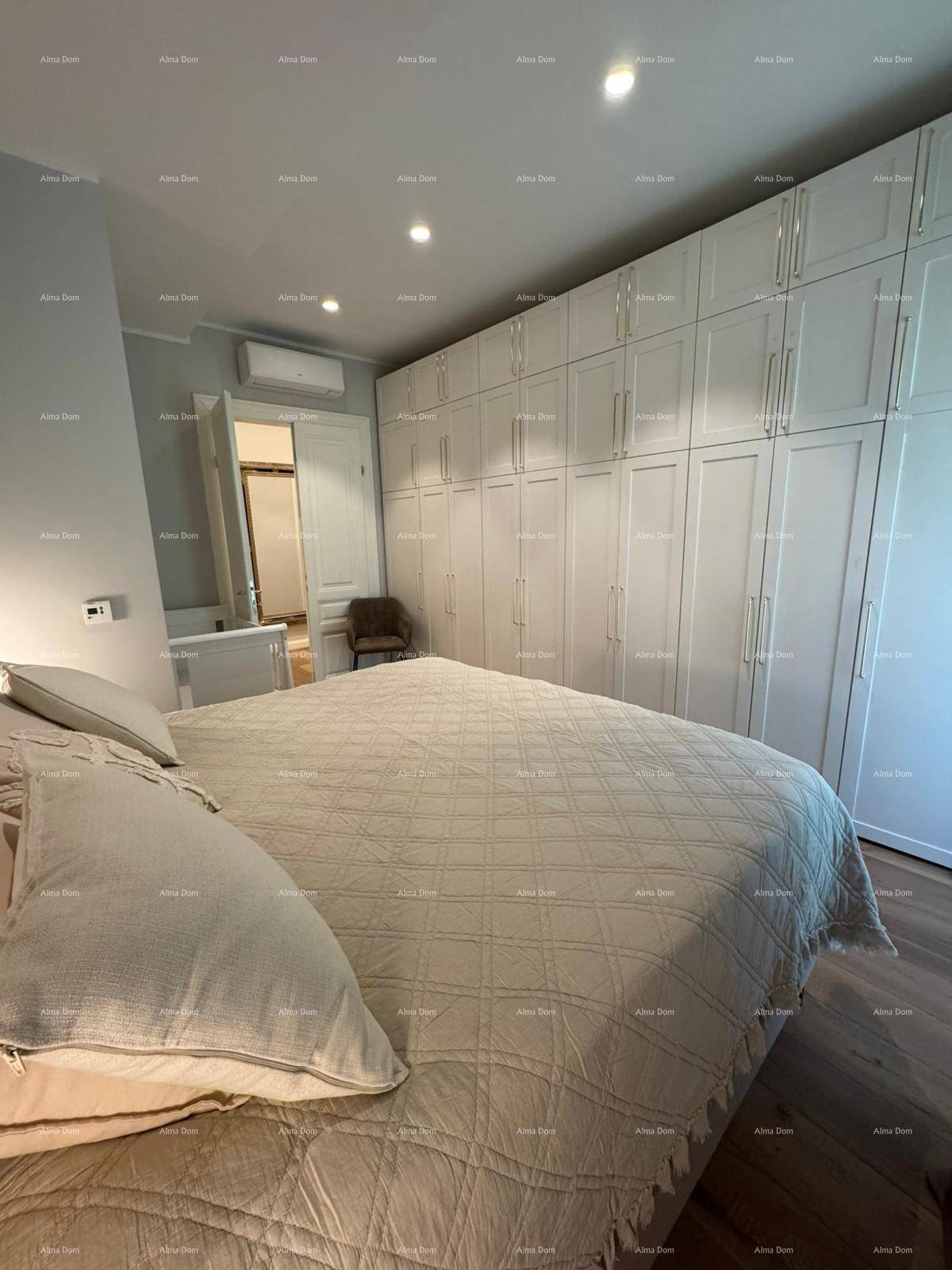 Schlafzimmer mit großem Bett, Einbauschränken und Holzboden.