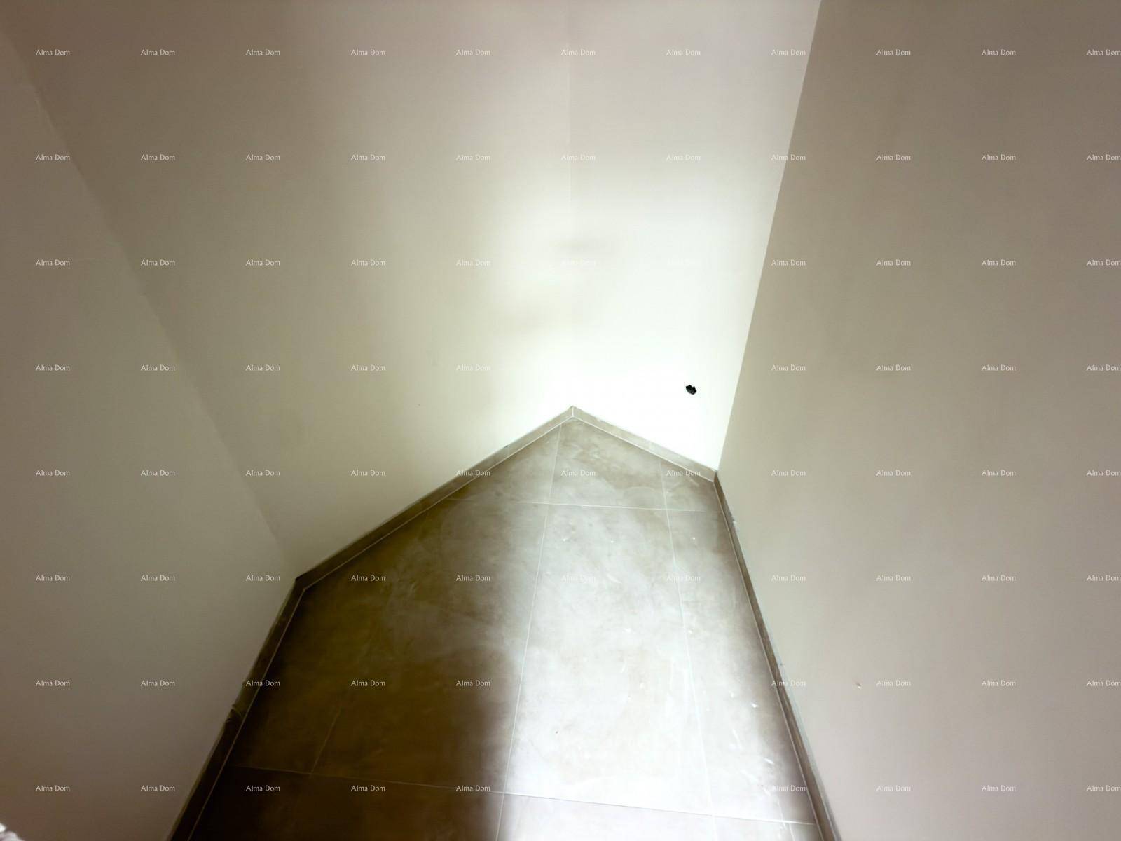 Ecke eines Innenraums mit schrägen Wänden und teilweise gefliestem Bereich, noch im Bau.