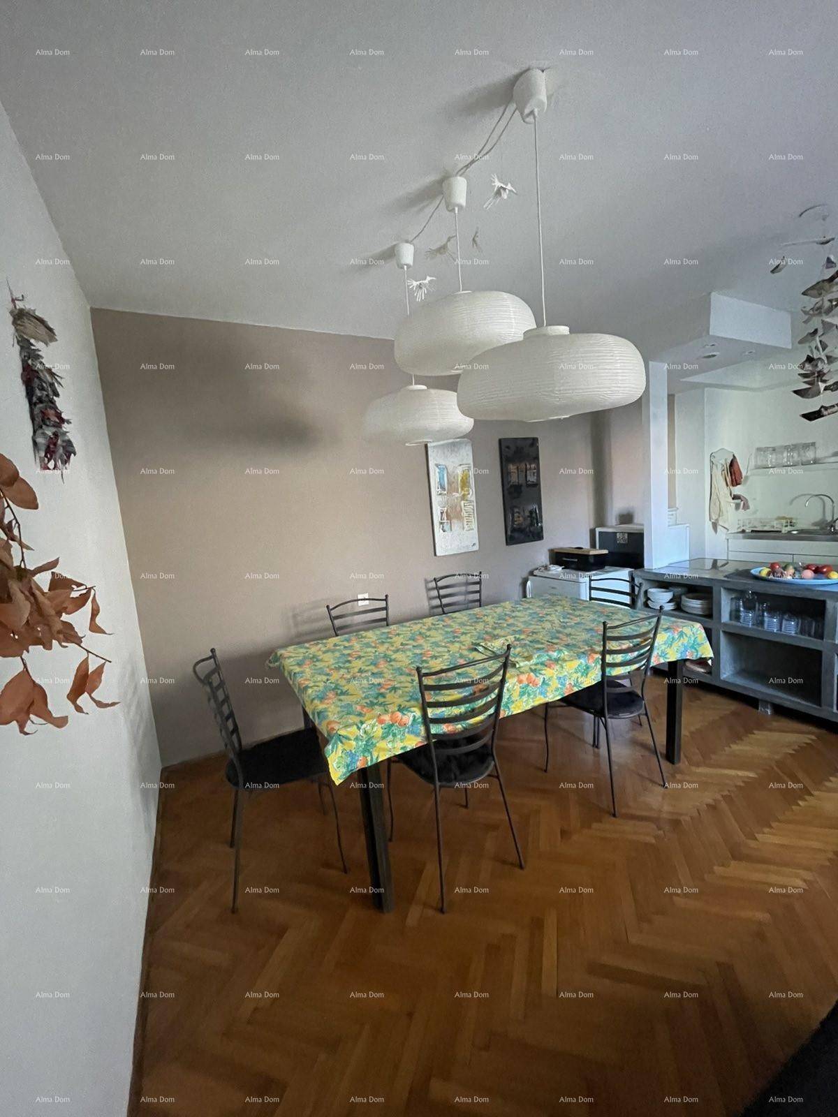 Essbereich mit Holzboden, großem Tisch und moderner Hängelampe, offen zur Küche.