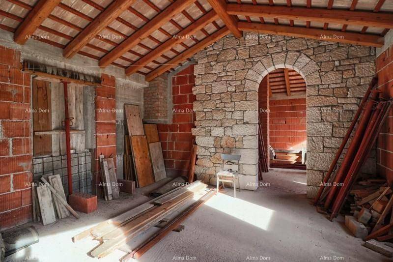 Rohbau-Innenraum mit Ziegelwänden, Holzbalken und Steinbogen, bereit für den Ausbau.