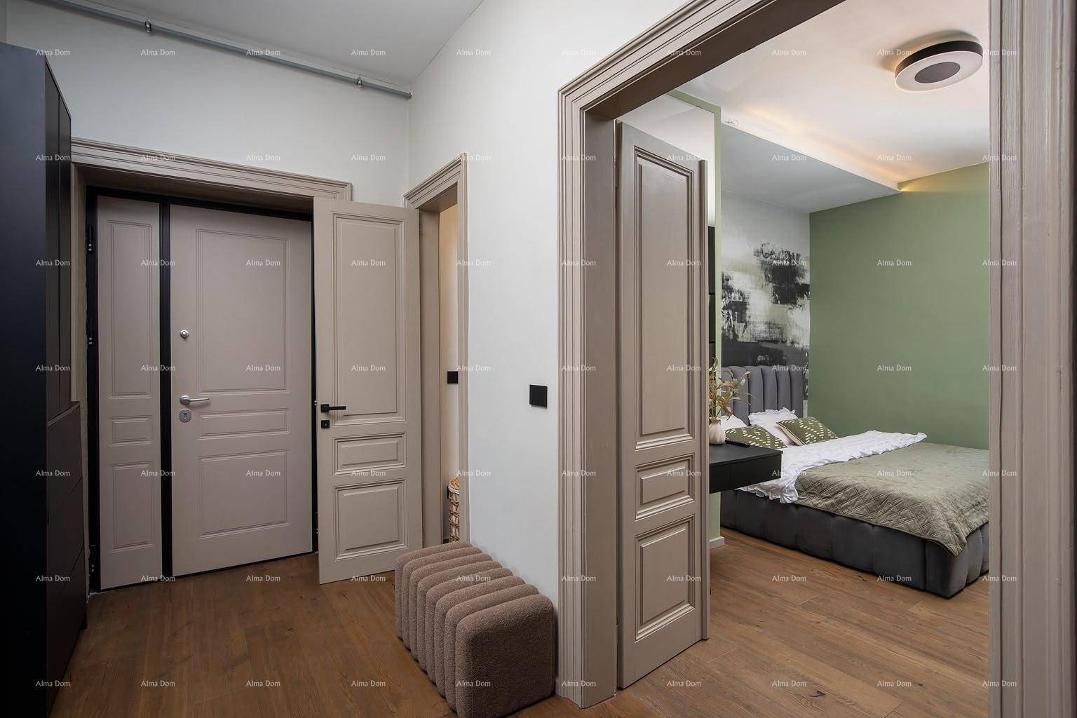 Flur mit Holzboden und Zugang zu einem Schlafzimmer, ergänzt durch eine kleine Sitzbank.