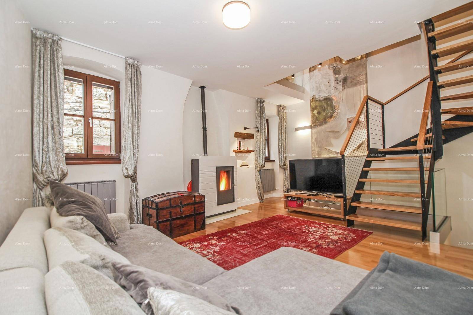 Heller Wohnbereich mit moderner Couch, Holzboden und einem Kaminofen als zentrales Element.