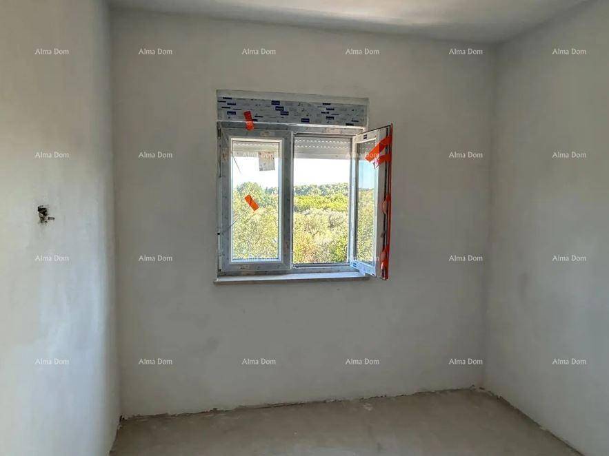 Helles, unfertiges Schlafzimmer mit einem geöffneten Fenster und Blick auf die umliegende Natur.