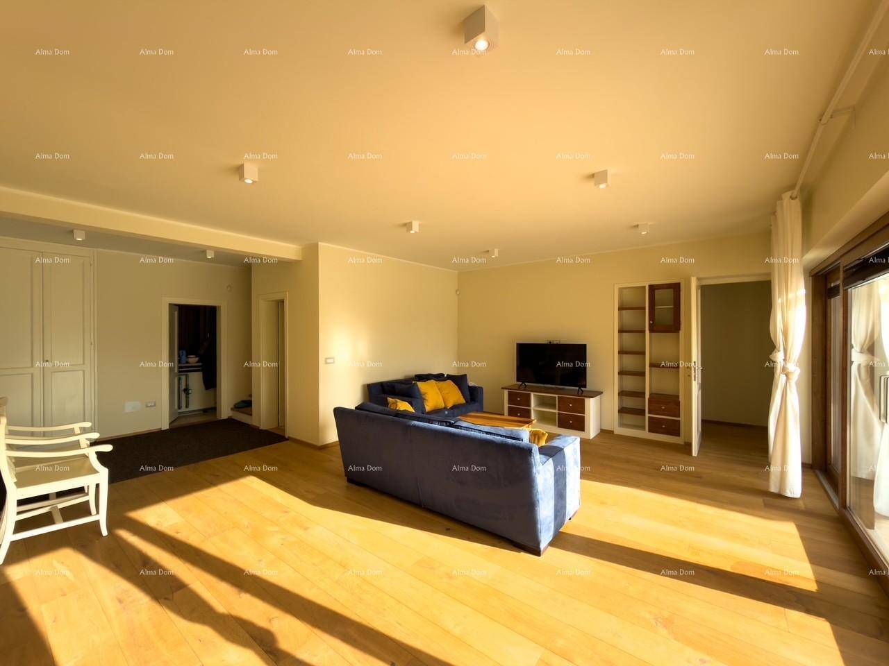 Helles Wohnzimmer mit Holzboden, blauen Sofas und Blick auf den Garten durch große Terrassentüren.