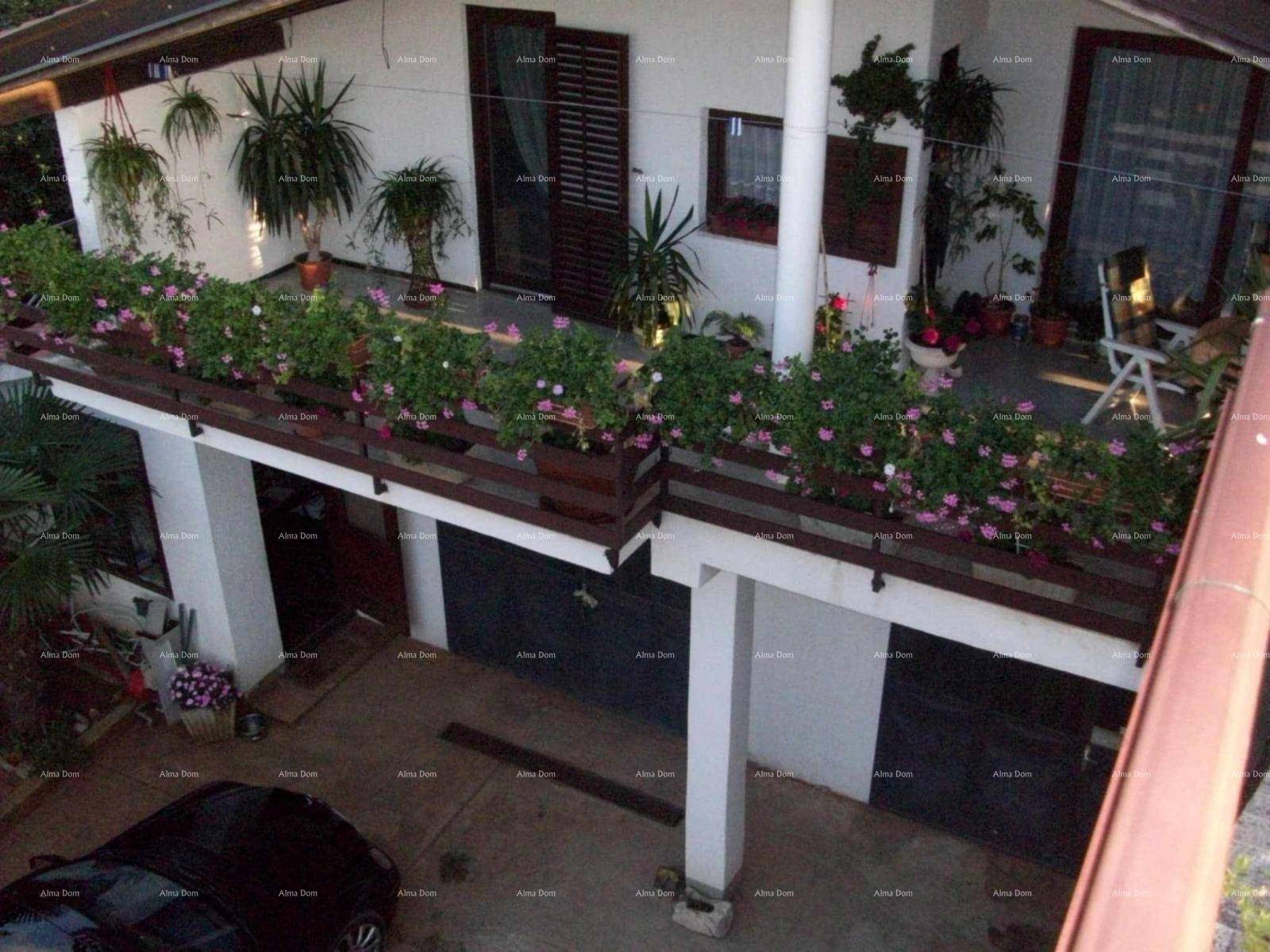Obere Terrasse mit Blumenkästen und Blick auf die Garagenzufahrt des Hauses.