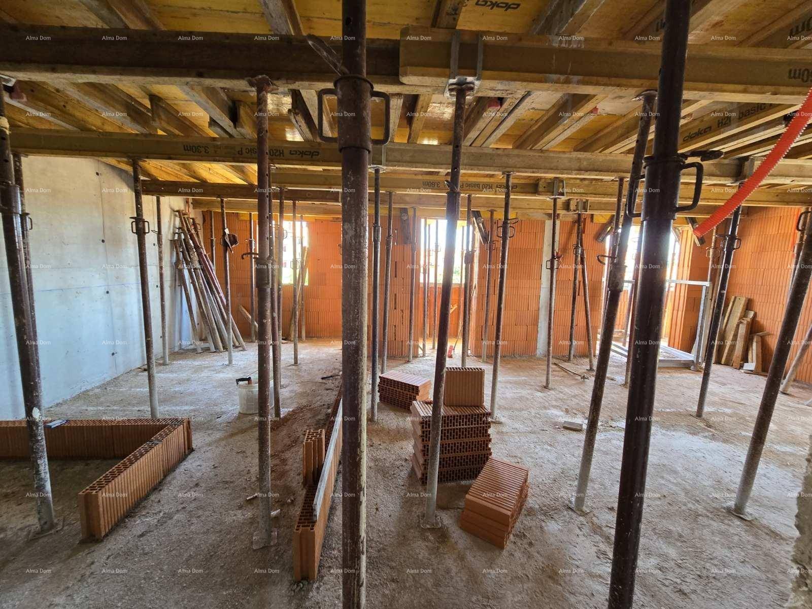 Rohbau eines Raumes mit Deckenverschalung, vielen Baustützen und Ziegelwänden.