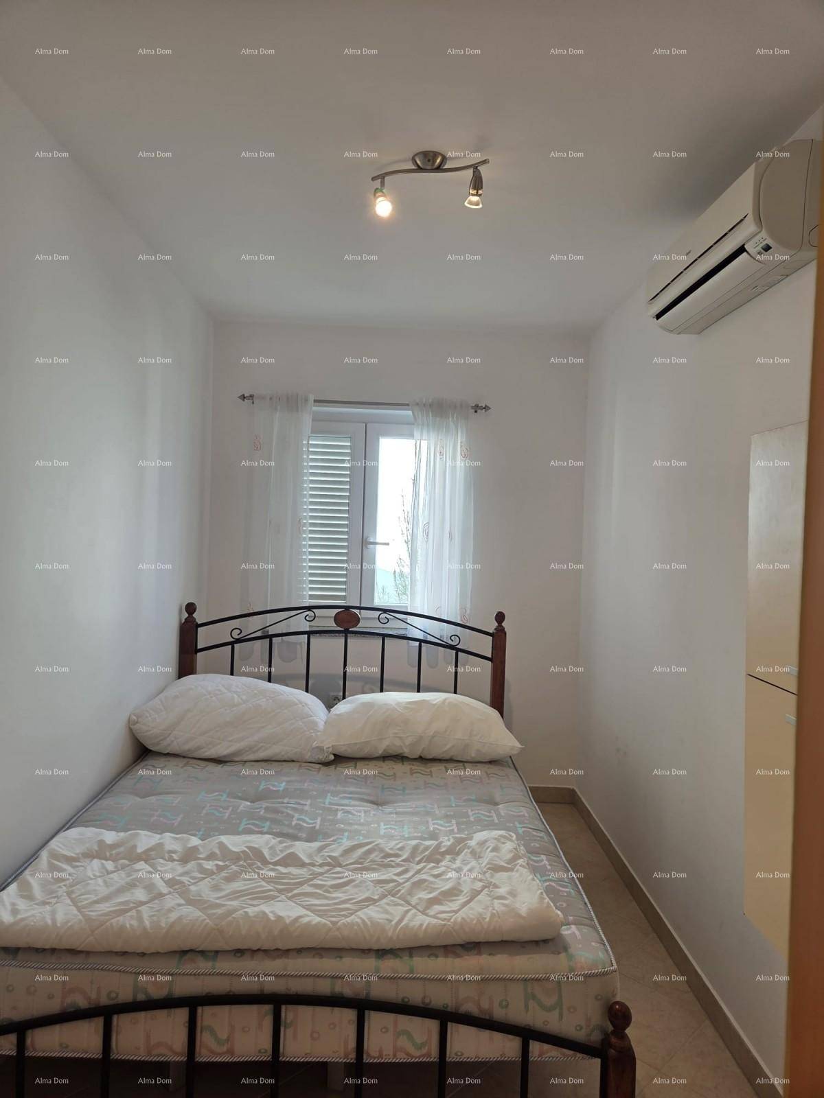 Schlafzimmer mit Doppelbett, Klimaanlage und Fenster mit Jalousien.