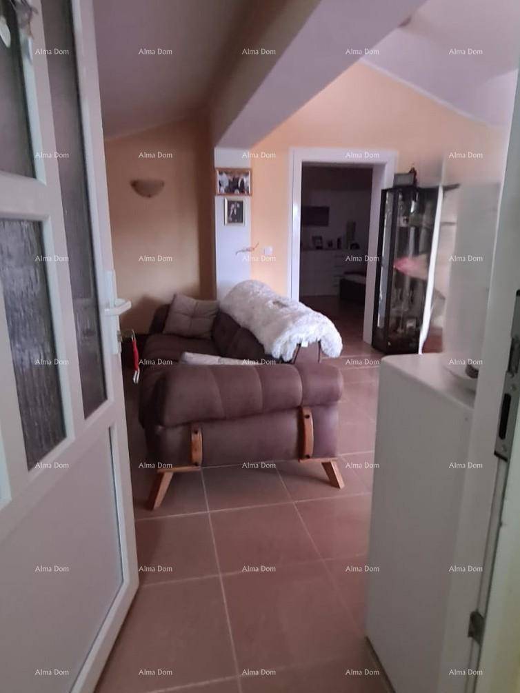 Gemütlicher Wohnbereich mit Sofa und Zugang zu einem weiteren Raum, hell beleuchtet.