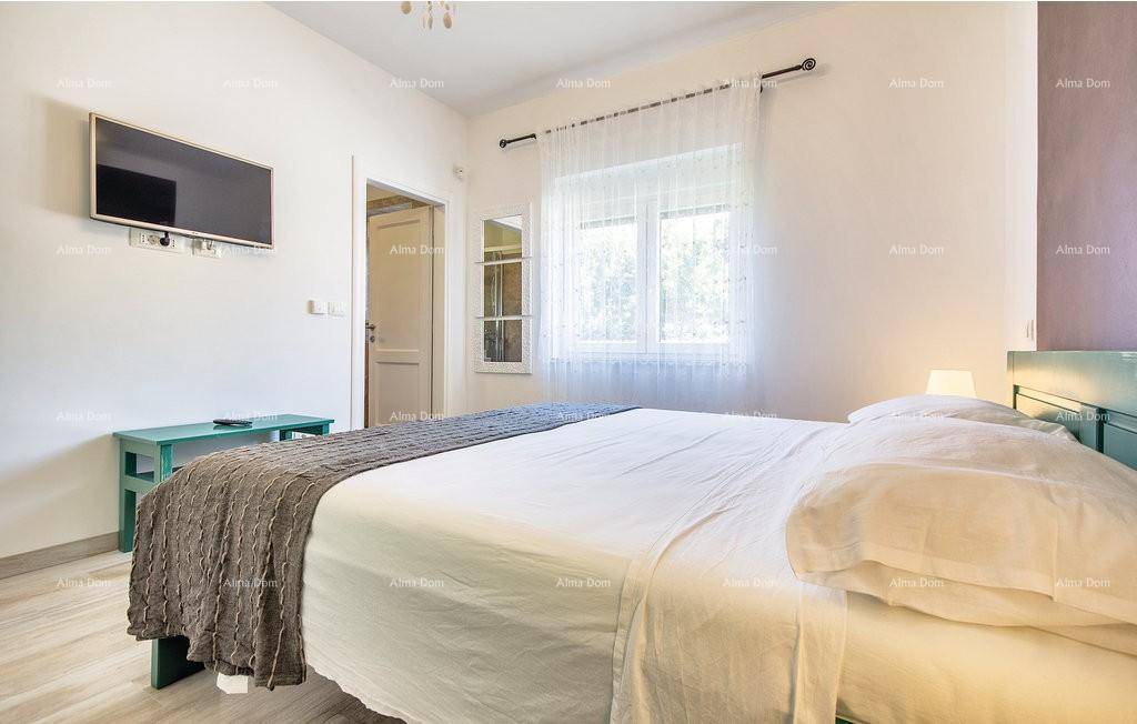 Schlafzimmer mit Doppelbett, Fernseher und Fenster für natürliches Licht.