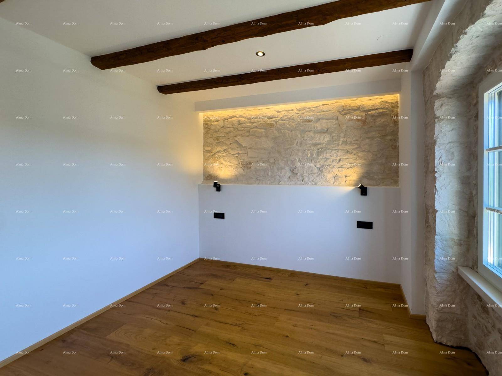 Geräumiges Schlafzimmer mit Holzbalkendecke, Holzboden und einer markanten Steinwand.