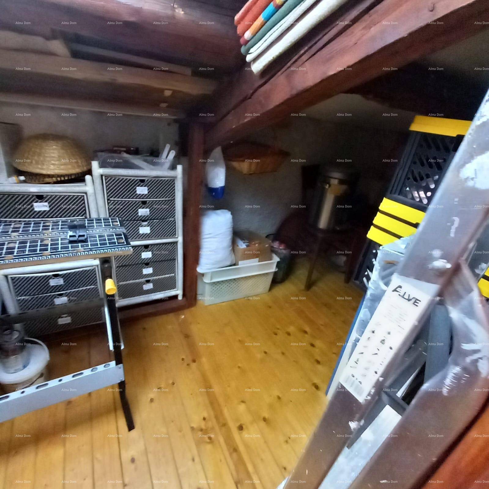 Geräumiger Abstellraum im Dachgeschoss mit Holzboden und verschiedenen Lagerlösungen.