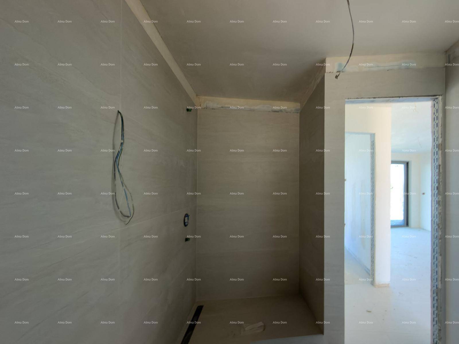Unfertiges Badezimmer mit gefliesten Wänden und vorbereitetem Duschbereich für den Ausbau.