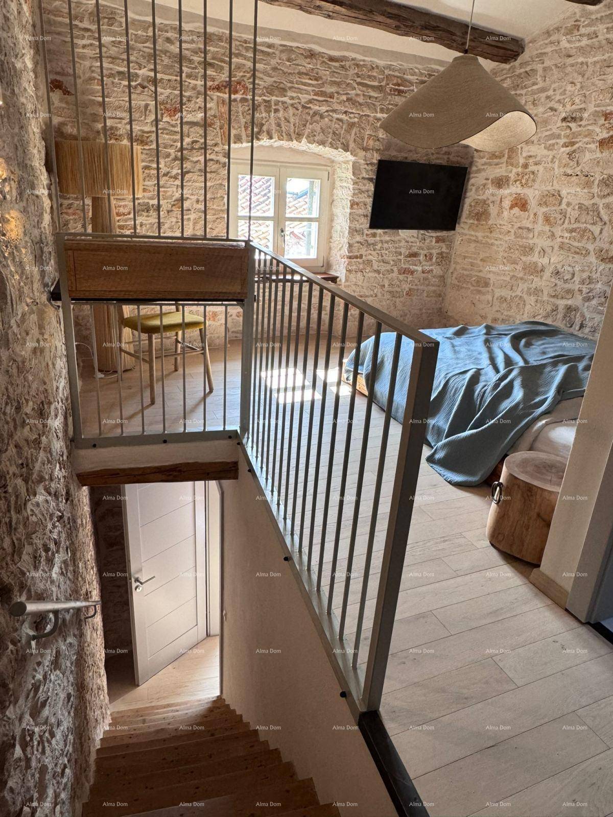 Schlafzimmer im Obergeschoss mit offener Galerie, Steinwänden und Holzbalkendecke.