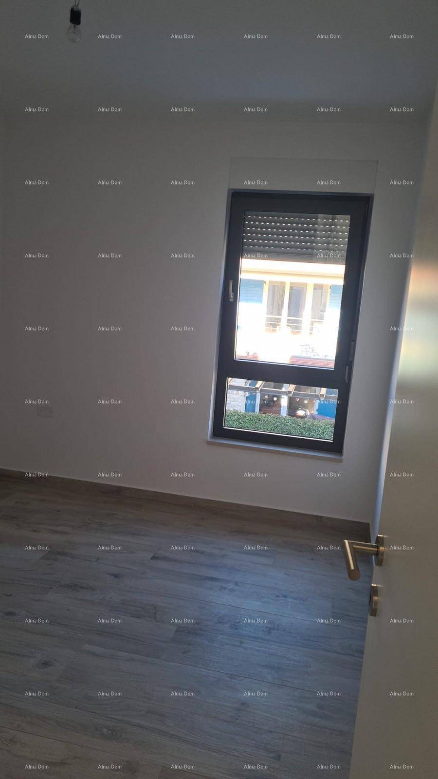 Heller Raum mit Holzboden, weiß gestrichenen Wänden und einem Fenster mit Rollladen.