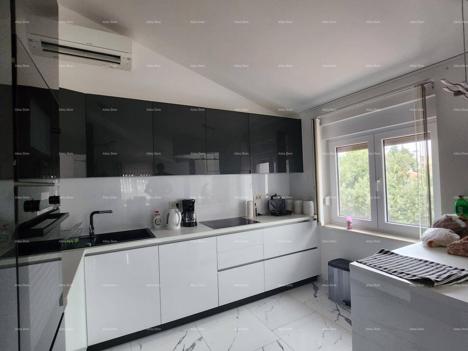 Moderne Küche mit weißen und grauen Hochglanzschränken, Induktionskochfeld und Klimaanlage.