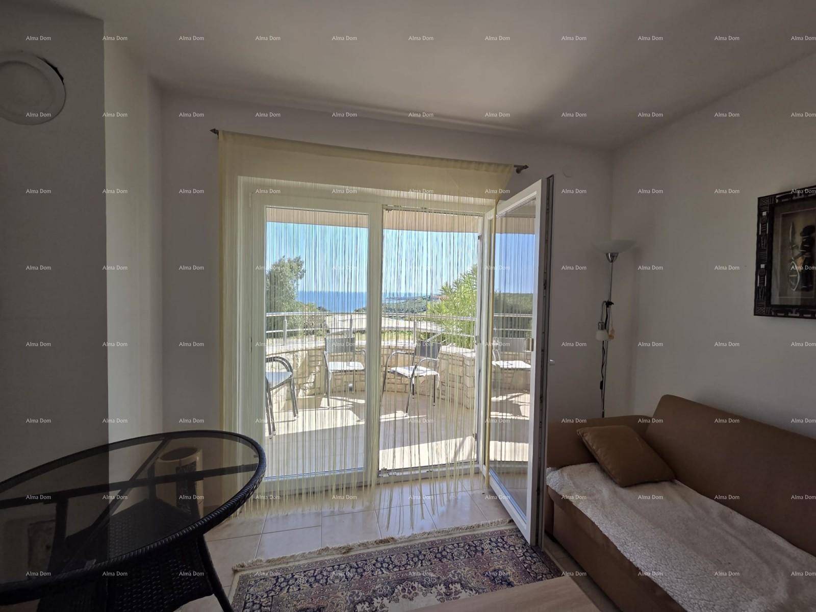 Helles Wohnzimmer mit Sofa, Glastisch und Zugang zu einer Terrasse mit Meerblick.